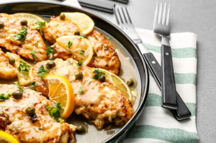 Chicken piccata with sauce and lemon on plate